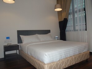 A neatly made bed with a headboard, a bedside table with a lamp, and a window with curtains. - 9 Square Hotel - Subang Jaya (Subang Jaya)