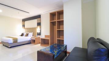 A hotel room with a bed, a desk, a wardrobe, and a sofa.
