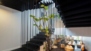 Ein modernes Interieur mit Treppe, Sitzgelegenheit und Essbereich.