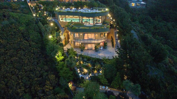 A multi-story building with a rooftop pool, surrounded by dense forest. - Zenith Boutique Lodge & Spa (Wellington)
