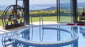 A swimming pool with a view of the ocean and hills. - Zenith Boutique Lodge & Spa (Wellington)