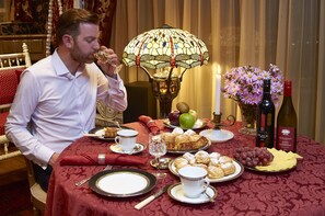 A dining table set with various dishes, a wine bottle, and a decorative lamp. - Zenith Boutique Lodge & Spa (Wellington)