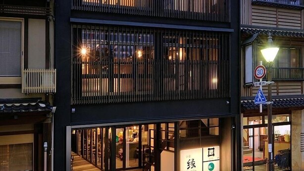 Un bâtiment moderne avec une entrée au rez-de-chaussée et des balcons aux étages supérieurs.