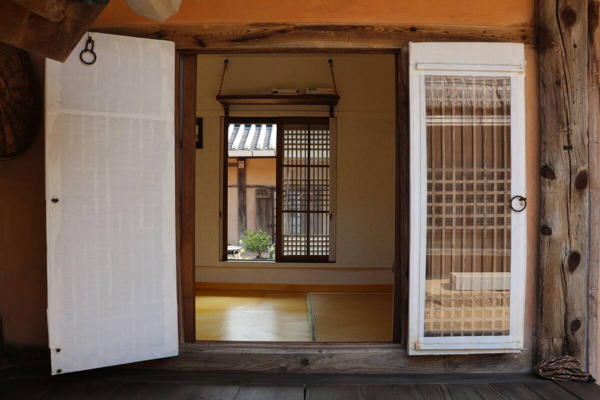 A traditional Japanese room with tatami flooring, a sliding door, and a shoji screen.