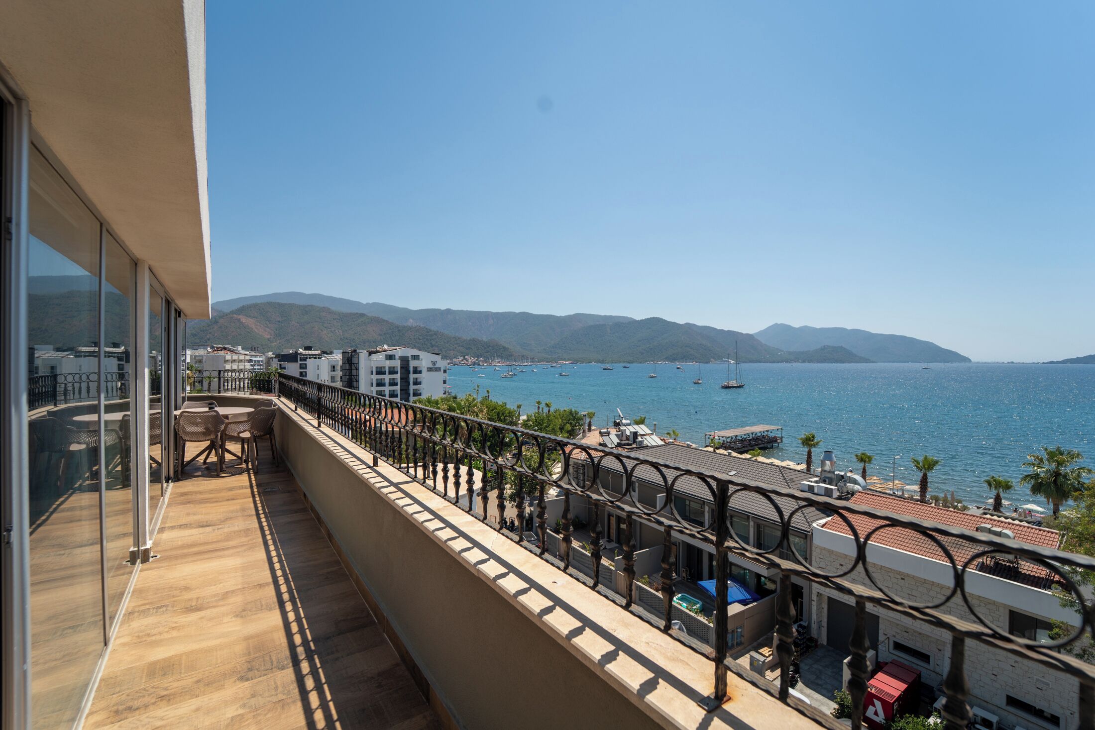 A balcony with a view of the sea and mountains.