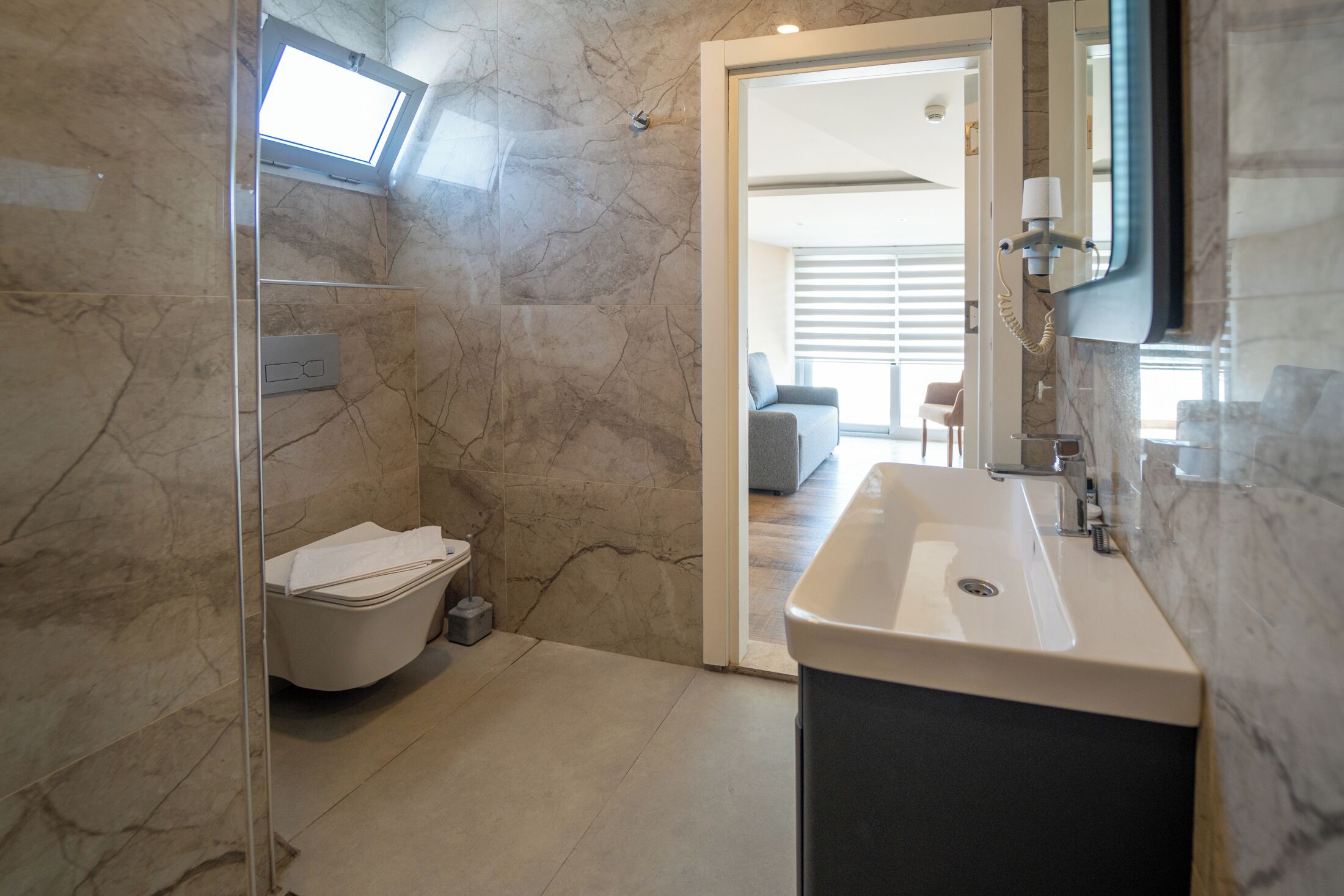 A modern bathroom with a large sink, a toilet, and a shower.