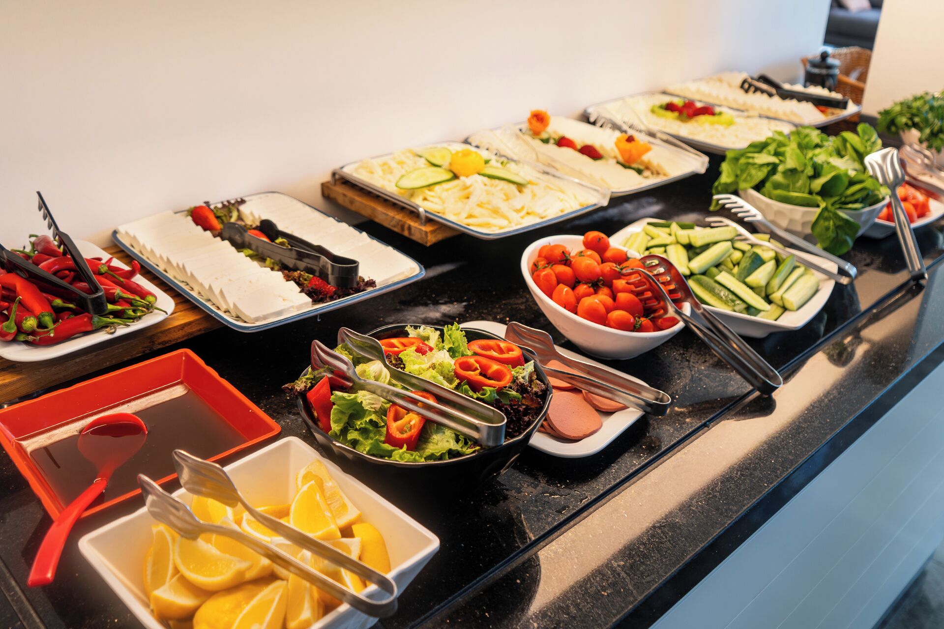 A buffet with various food items including salads, fruits, and vegetables.