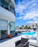 Una piscina al aire libre, sombrillas, tumbonas