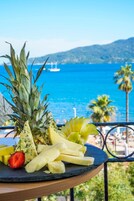 Una bandeja de frutas en un balcón con vista al mar y a las montañas.