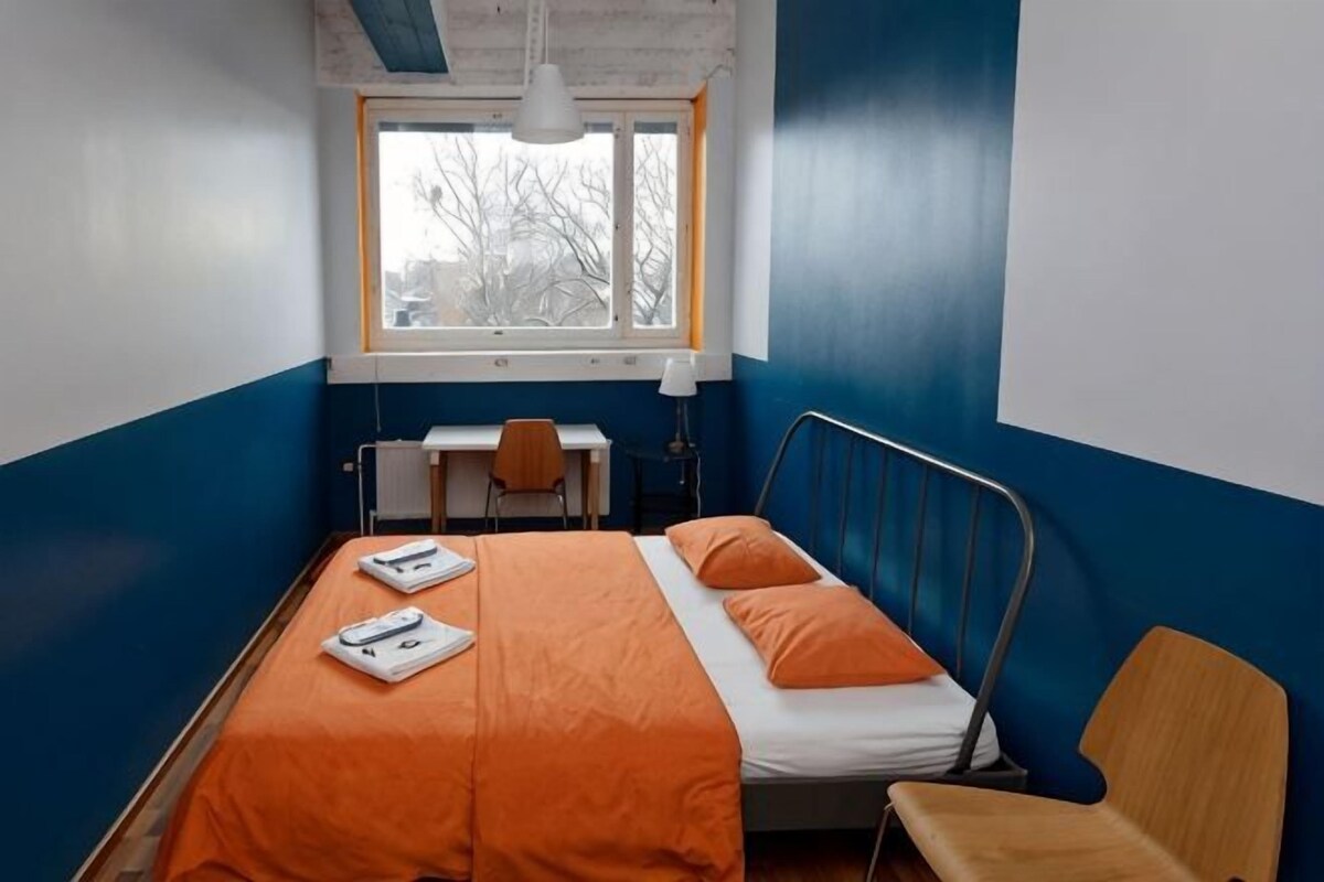 A room with a bed, a desk, and a chair.