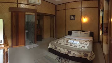 A hotel room with a bed, a television, a bathroom, and a small desk.