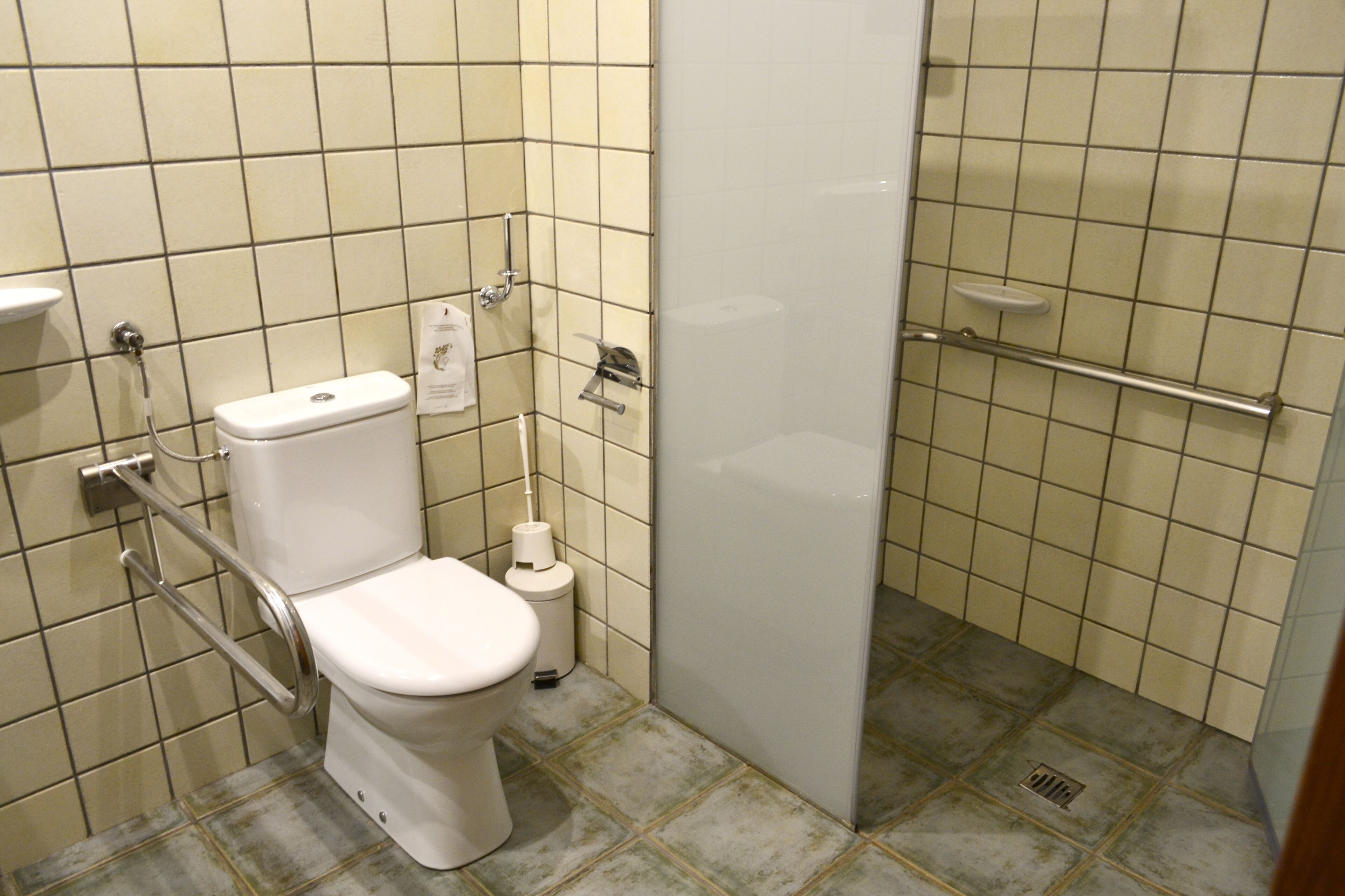 Ein Badezimmer mit Toilette, einem Händetrockner und einer Duschkabine.