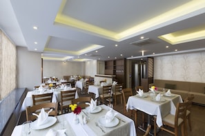A restaurant with multiple dining tables, each set with white tablecloths, plates, and glasses. - Regard Hotel (Istanbul)