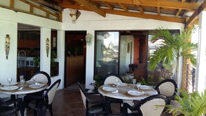 A restaurant with outdoor seating, wooden beams, and potted plants. - Antonio's Pension House (Dipolog)