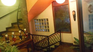 A staircase with a black railing, a wall with a window, and a door with a Wi-Fi symbol. - Antonio's Pension House (Dipolog)