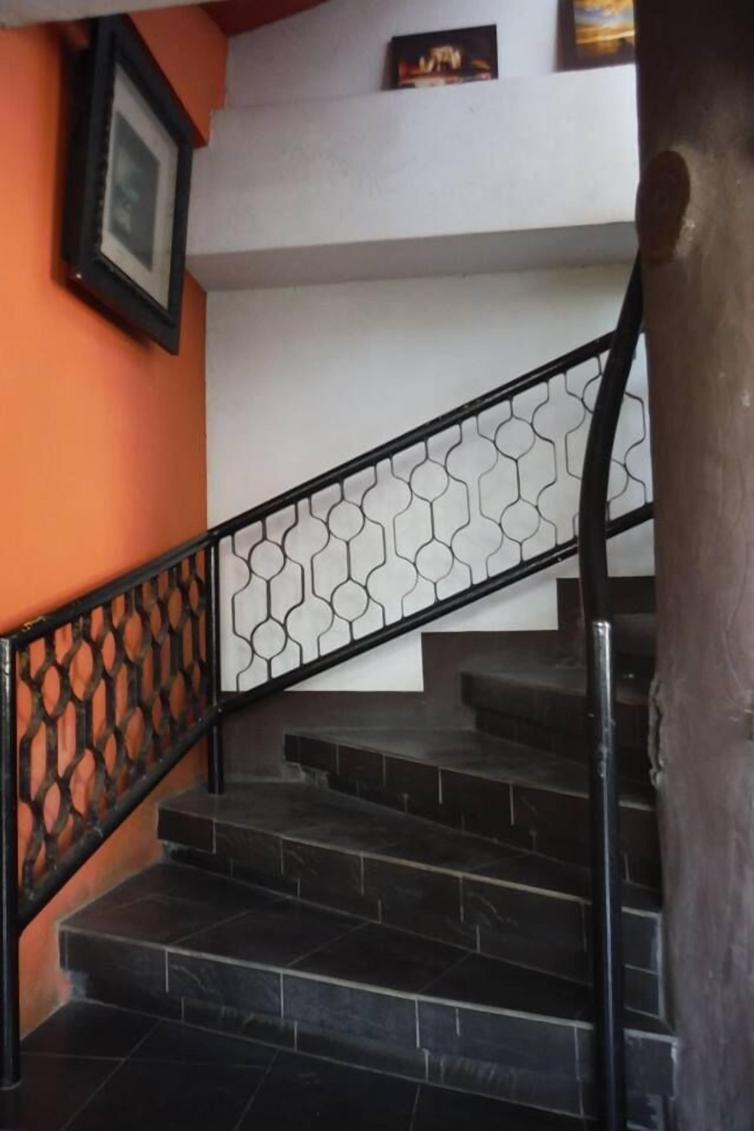 A staircase with a black metal railing and a geometric pattern.
