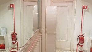 A hallway with two doors, a fire extinguisher, and a mirror reflecting the space. - Chain Vatican Suites (Rome)