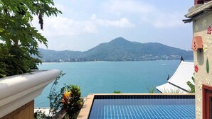 Uma piscina com vista para um lago tranquilo e uma montanha ao longe.