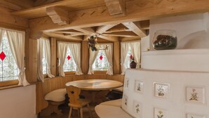 Un interior acogedor de cabaña con una mesa de comedor de madera, bancos y paneles decorativos en la pared.