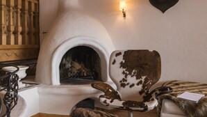 Una habitación acogedora con chimenea, un sillón mullido y una manta de piel.