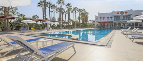 Una piscina al aire libre de temporada, sombrillas