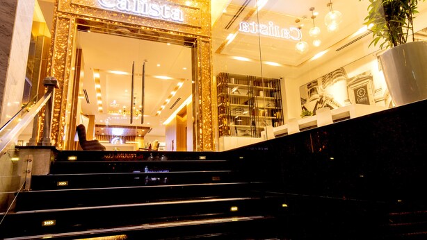 Ein Hotel mit einem repräsentativen Eingangsbereich und einer imposanten Treppe zum Empfang.