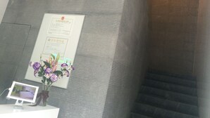 Un comptoir d’accueil orné d’un certificat encadré, d’un petit écran et d’un vase de fleurs.