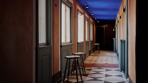 A hallway with patterned flooring, multiple windows, and bar stools. - Boutique Hotel Danmark (Copenhagen)