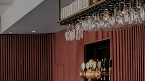 A bar area with a counter, stools, and a wine rack. - Boutique Hotel Danmark (Copenhagen)