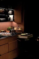 A modern kitchen with wooden cabinets, a built-in stove, and a countertop with various kitchen items.