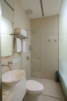 A modern bathroom with a sink, toilet, and glass shower enclosure.