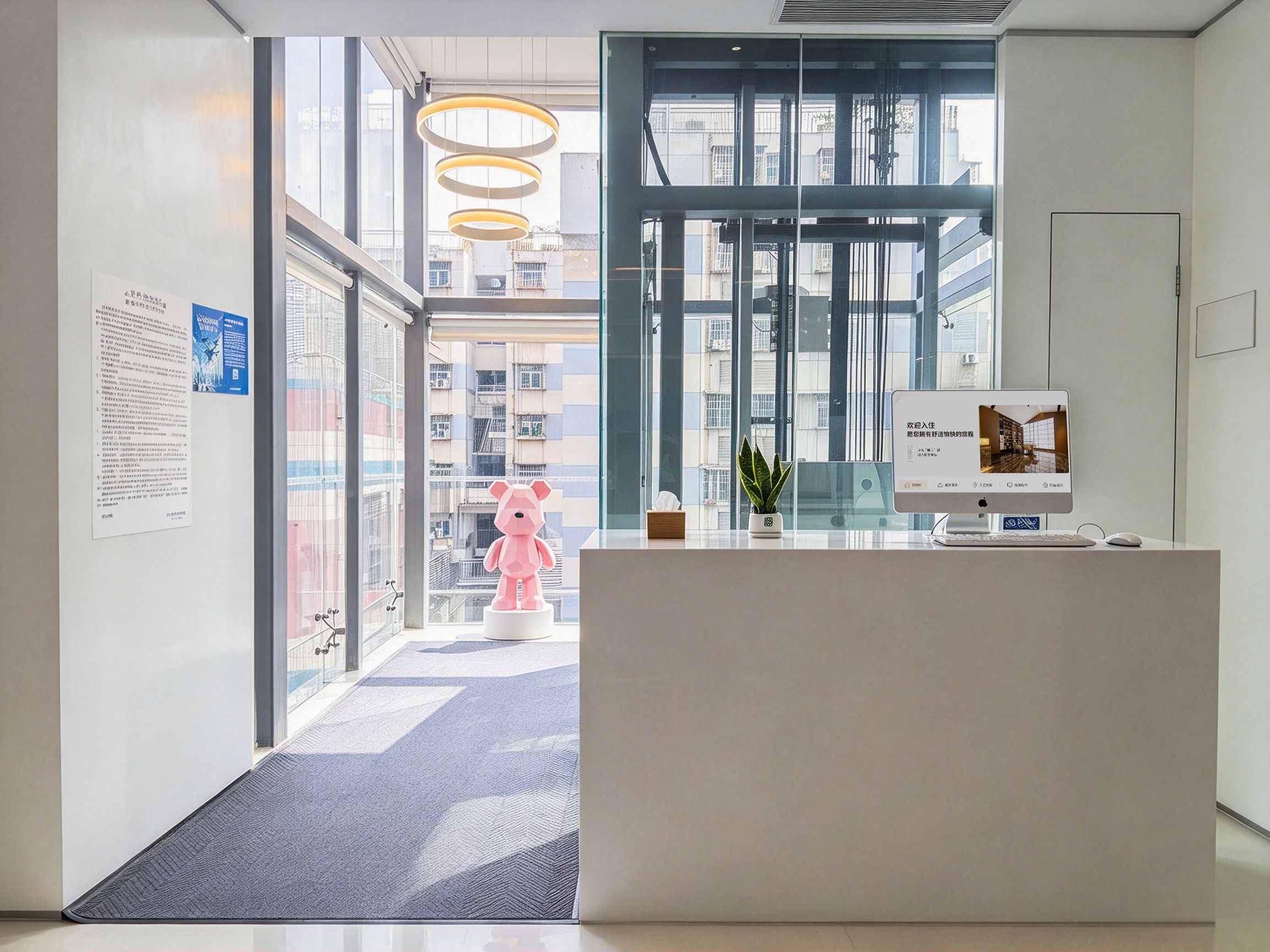 A reception area with a desk, a potted plant, and a large window.