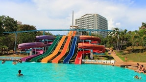A water park with multiple colorful slides and a swimming pool. - Pintree Service Apartment Pattaya (Pattaya)