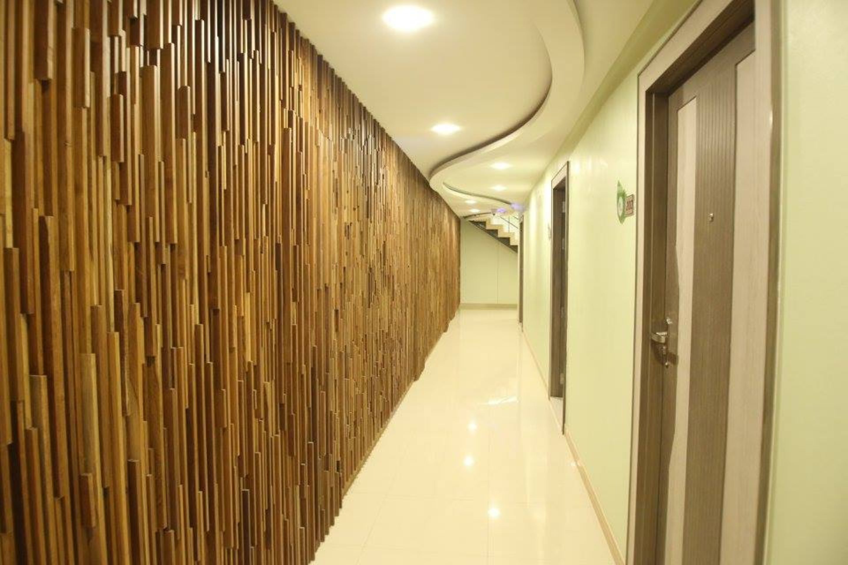 Un couloir avec un lambris en bois et un plancher ciré.