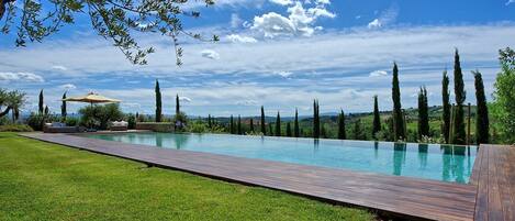 En säsongsöppen utomhuspool och solstolar