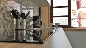 A kitchen counter with a coffee maker, cups, and utensils. - D&S - Porto São Bento Apartments I (Porto)