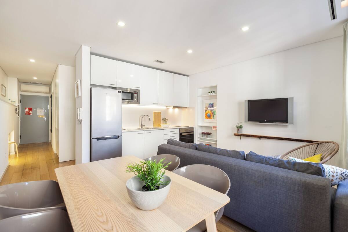 Un appartement moderne comprenant une cuisine, un coin repas et un salon.