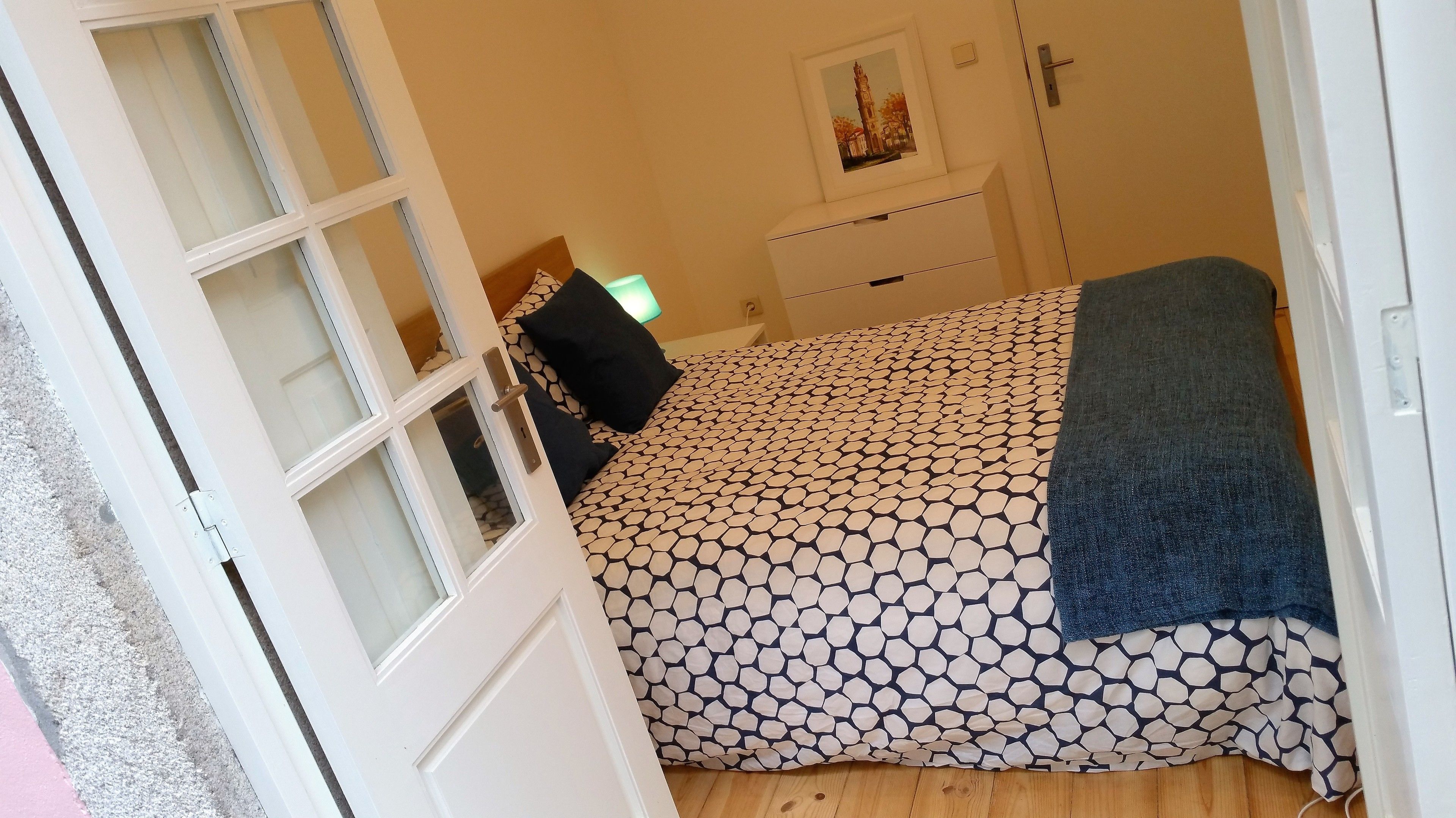 Ein Schlafzimmer mit einem Bett, einem Schminktisch, einer Tür und einem Fenster.