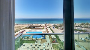 A resort view with a pool, beach, and clear blue sky. - Musho Hotel (Ayvalik)