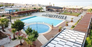 Piscine couverte, piscine extérieure, parasols de plage, chaises longues