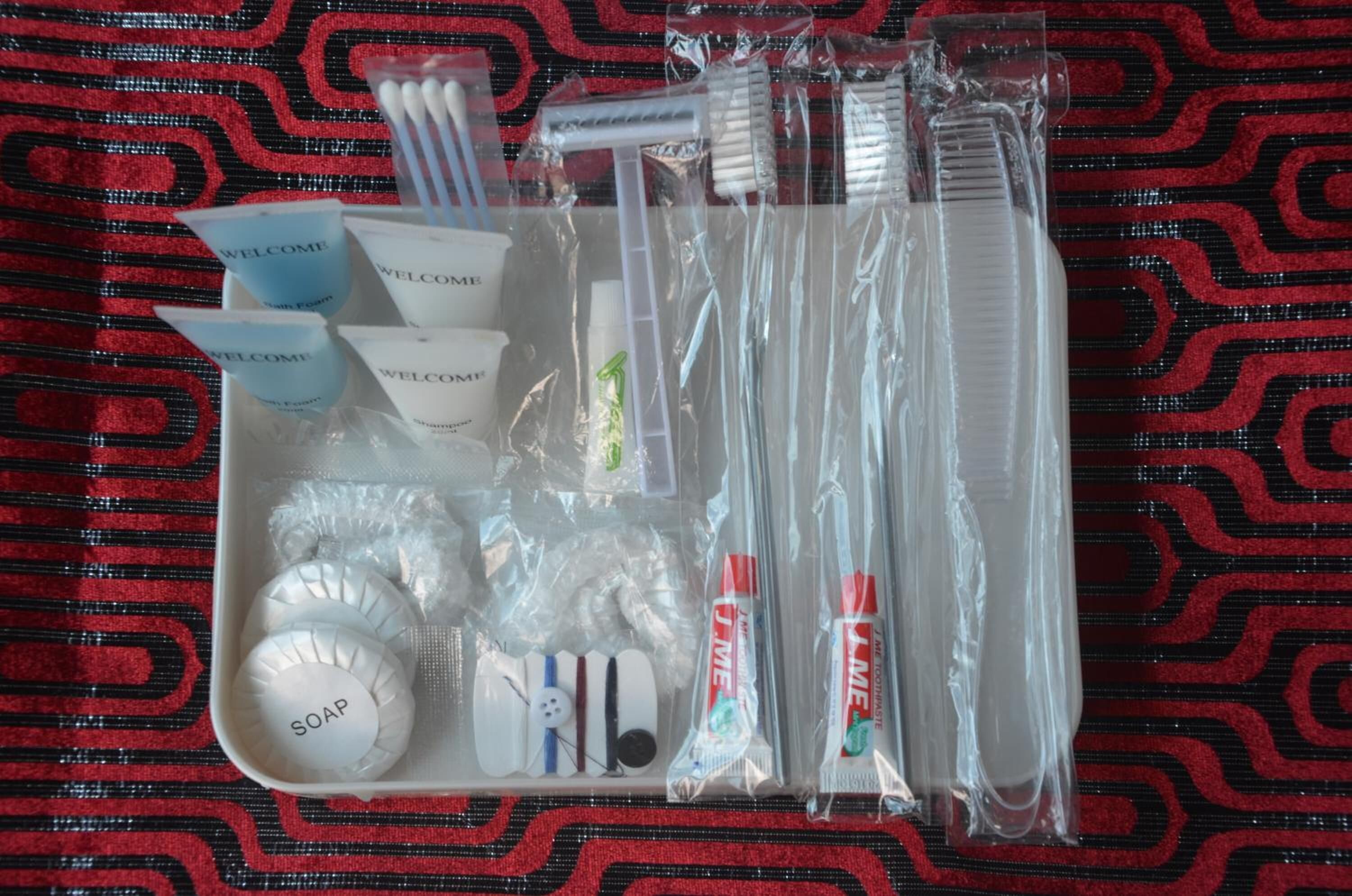 Un kit de viaje con artículos de aseo personal, incluyendo jabón, cepillos de dientes y champú.