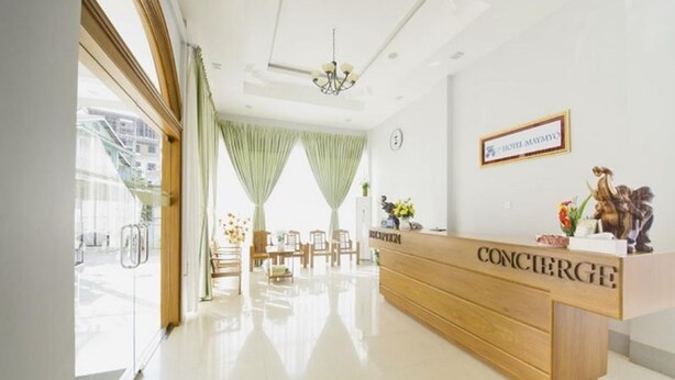 A hotel reception area with a wooden reception desk, a chandelier, and a sign that reads "CONCIERGE". - Hotel Maymyo (Pyin Oo Lwin)