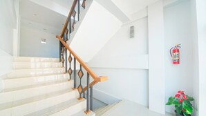 A staircase with a wooden handrail and white walls. - Hotel Maymyo (Pyin Oo Lwin)