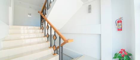 A staircase with a wooden handrail and white walls.