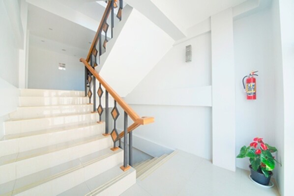 A staircase with a wooden handrail and white walls.