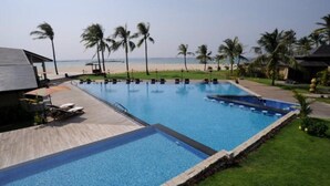 Une piscine avec vue sur la plage et les palmiers.