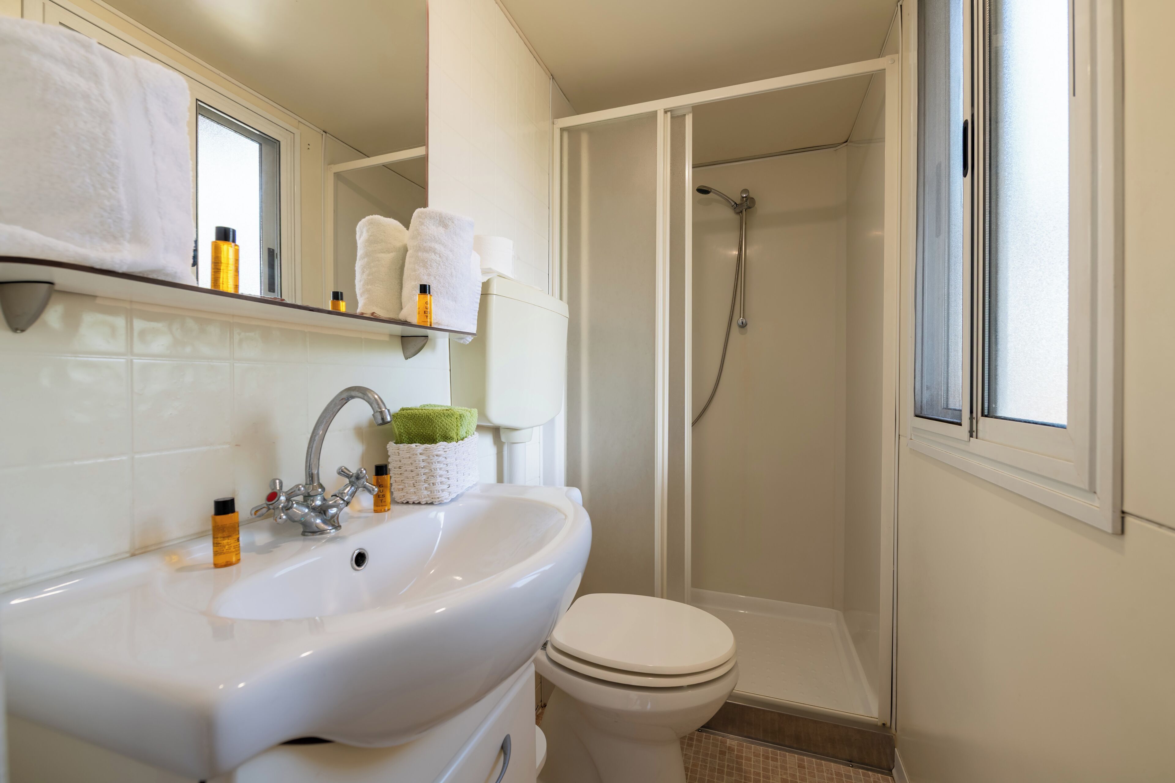 A bathroom with a white sink, toilet, and shower.