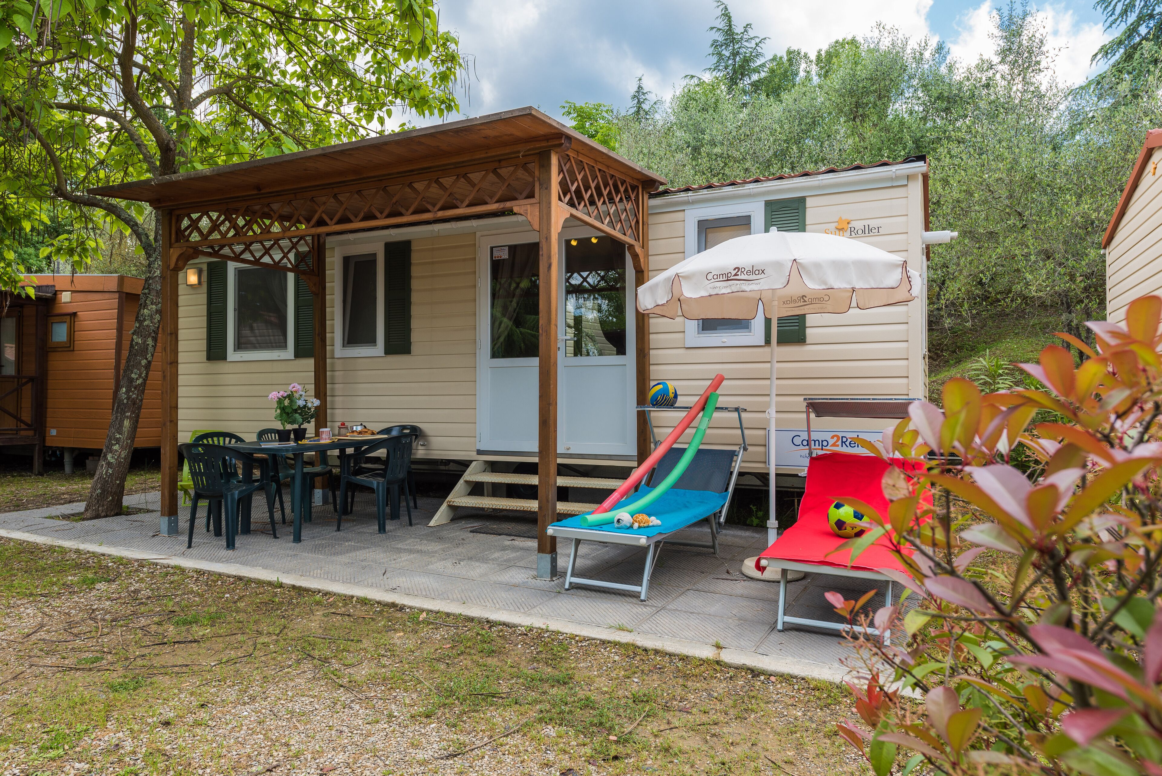 A covered patio area with a table and chairs, a slide, and a small pool.