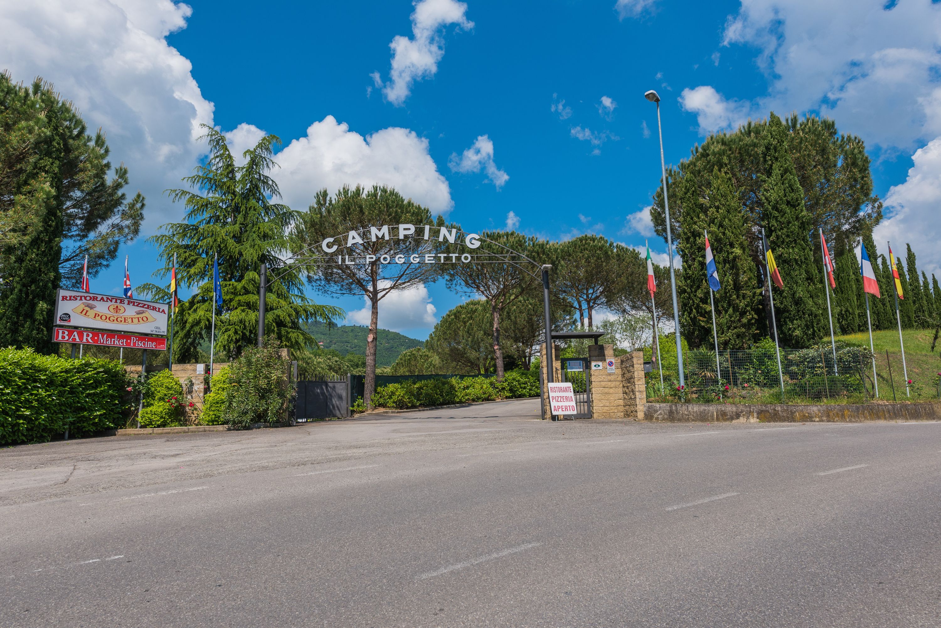A road leading to a camping area with a sign for a restaurant and bar.