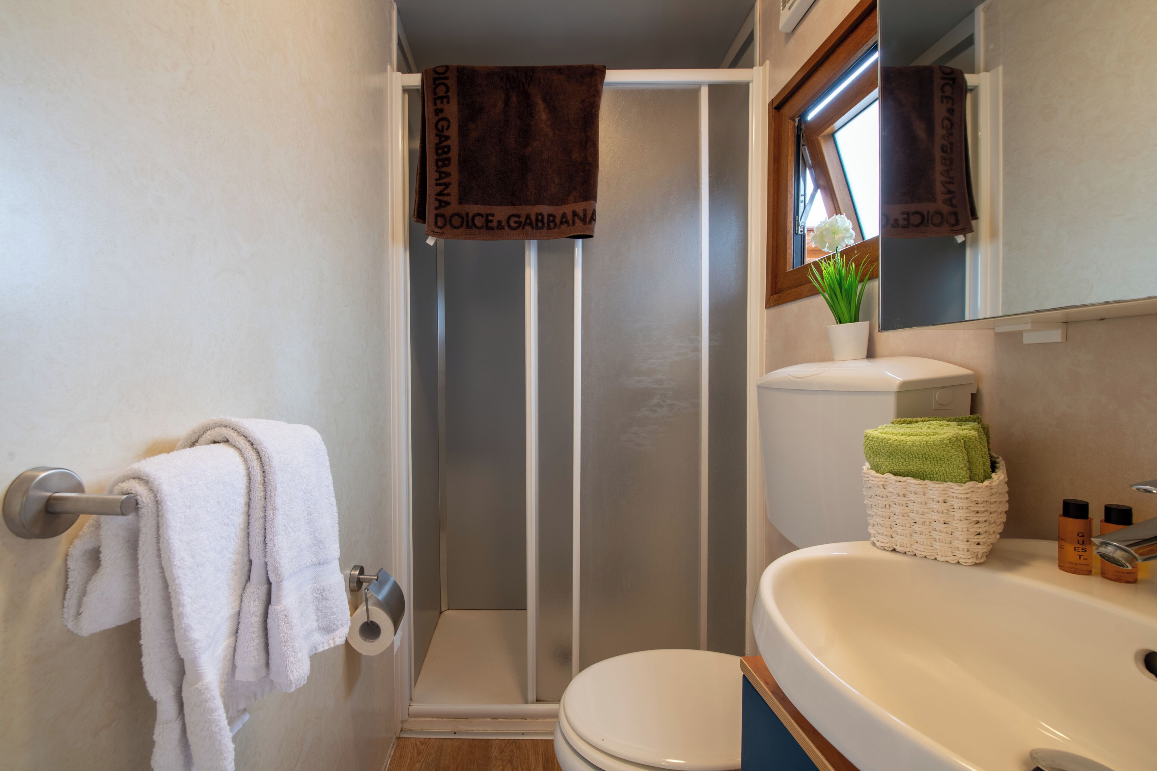 Een badkamer met douche, toilet en wastafel.